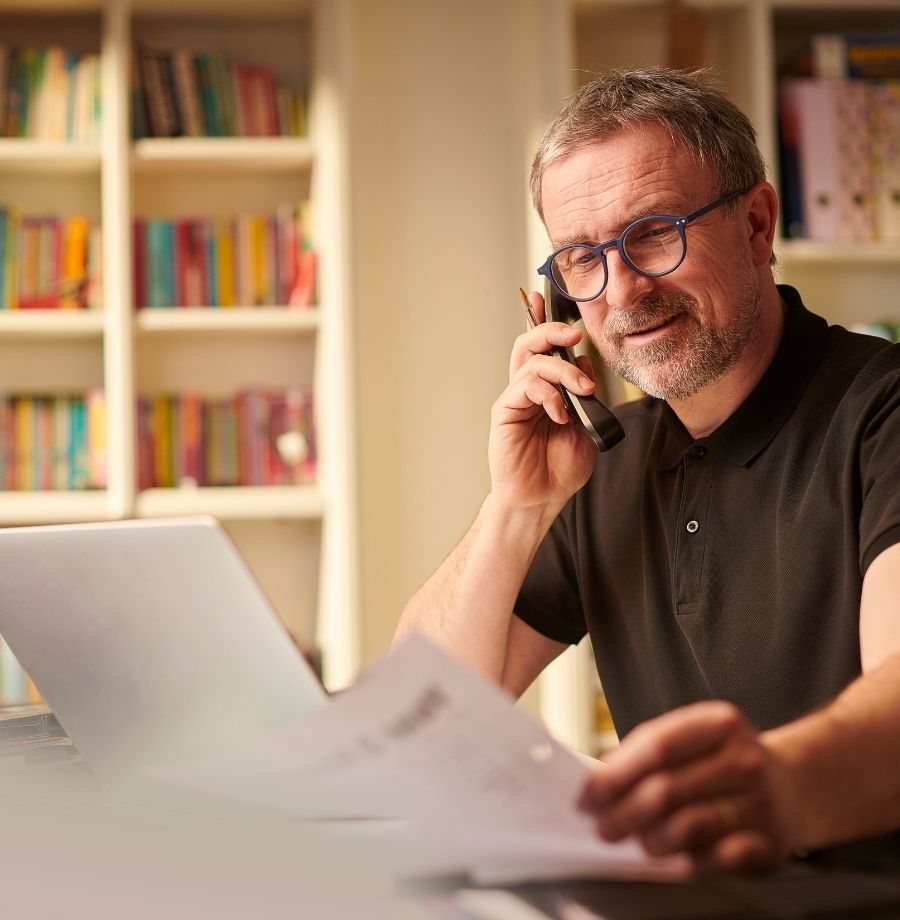 Small business owner at desk reviewing MCA debt settlement options