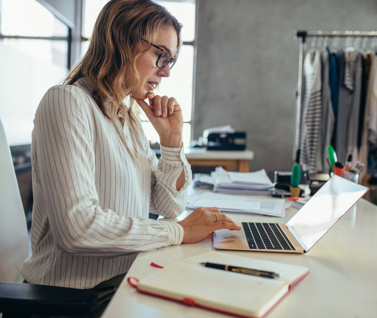 Small business owner at her laptop comparing merchant cash advance settlement companies
