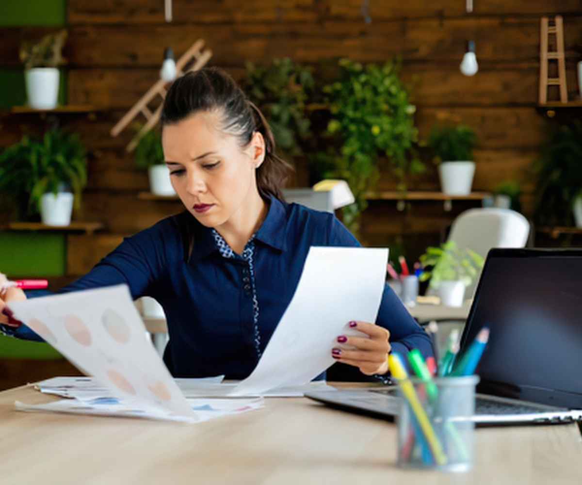 Business owner reviewing merchant cash advance paperwork while weighing declaring financial hardship