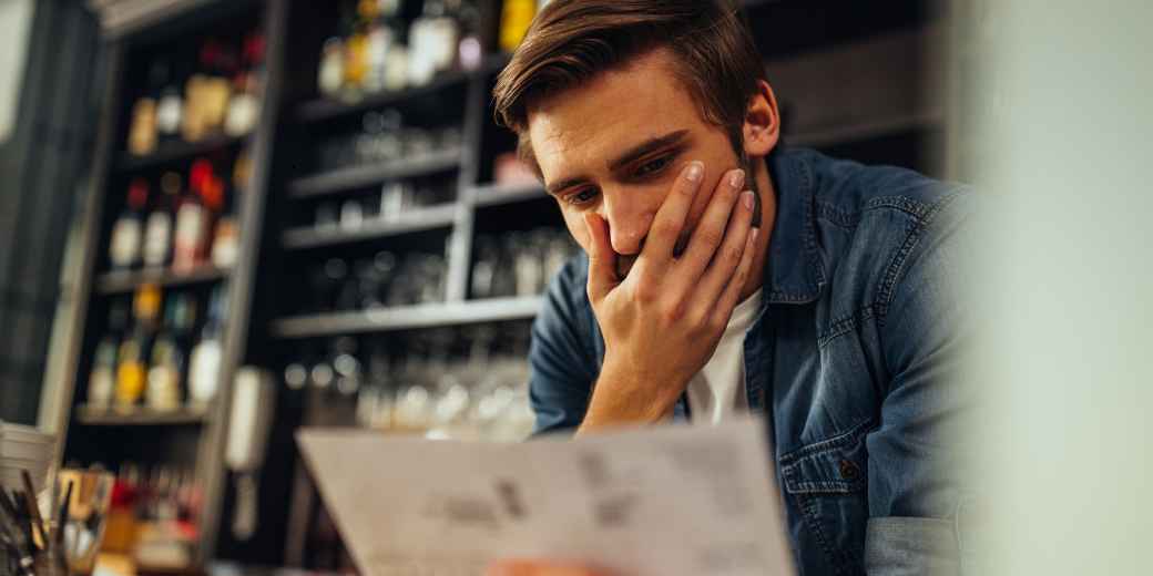 Wine shop owner reviewing paperwork in his store