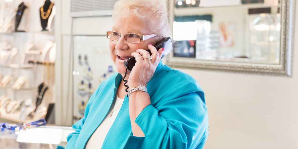 Jewelry store owner on the phone at the counter of her shop